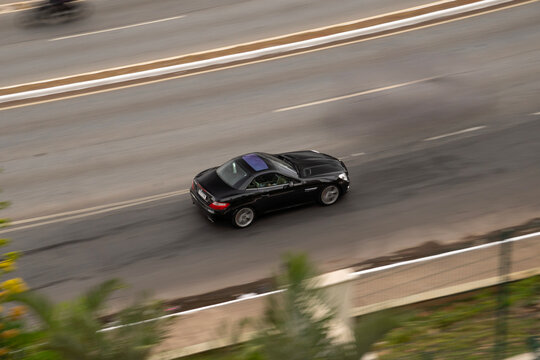 Black Mercedes-Benz SLK panning shot, Luxury convertible sportscar cruising highway