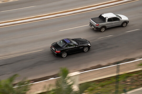 Black Mercedes-Benz SLK panning shot, Luxury convertible sportscar cruising highway