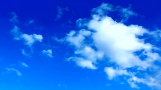 A serene blue sky with a single fluffy white cloud drifting lazily
