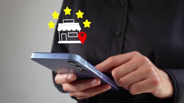Businesswoman interacting with her mobile phone, viewing an animation of a five-star rating for a local store.