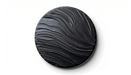 Circular black object with textured, wavy surface, set against a bright white backdrop