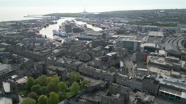 High altitude aerial drone shot showcasing the historic granite architecture of Union Street with the Aberdeen harbor and North Sea in the background.