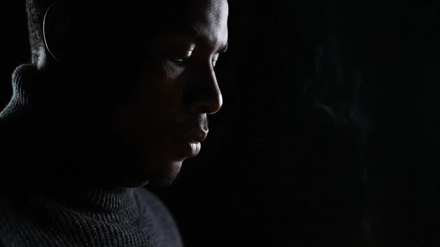 Close up of a man lighting a lighter in the dark.