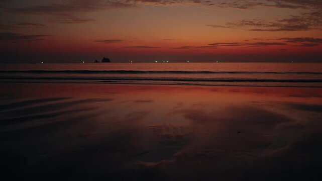Deep Orange Sunset Sky Over Calm Waves At The Beach In Ranong, Thailand. wide shot