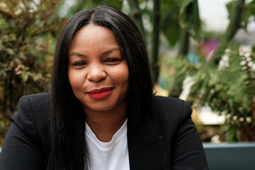 Confident businesswoman smiling in urban garden setting