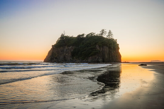 Ruby Beach at dusk in Olympic National Park, Washington. Vibrant sunset colors, coastal rocks, and ocean waves create a serene wilderness scene.