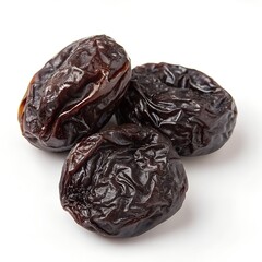 Three dried dates with wrinkled dark brown shiny surface texture white background