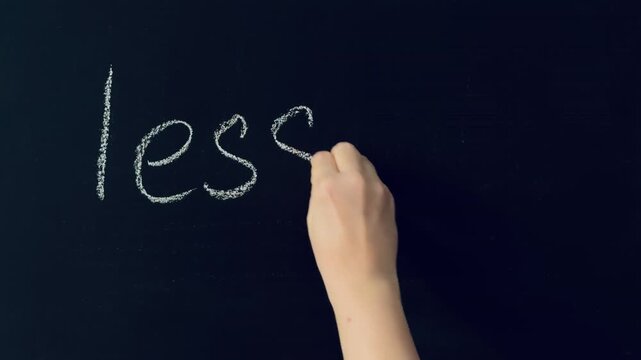 Female hand writing the word "Lesson 3" in chalk on black slate board. Education, learning process, school or course concept.