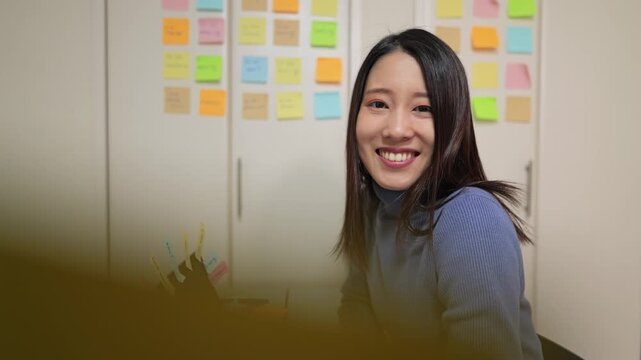 付箋を貼る笑顔の女性のクローズアップ