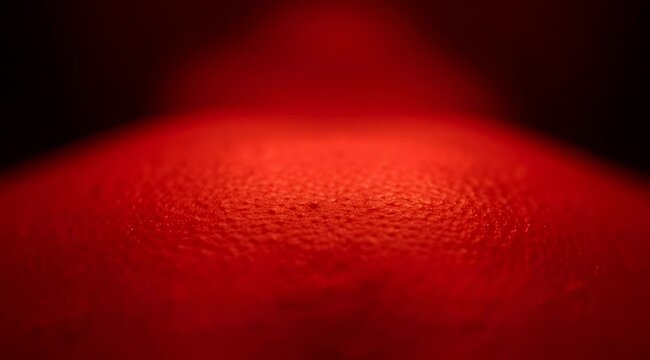 Closeup skin illuminated red light therapy for skincare treatment, showcasing texture and therapeutic benefits with red wavelength light
