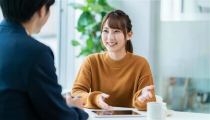 Obraz premium 茶色のニットを着て身振り手振りで提案する笑顔の女性