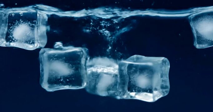 Ice cubes floating on a dark blue background, viewed from directly above, with water splashing around them