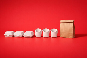 Fast food takeout boxes and fries cartons on red background