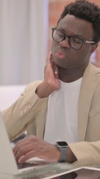 African American Man with Neck Pain Working on Laptop, vertical video