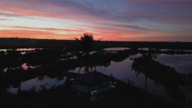 Left-side aerial view of Tondol road beside rice fields, bathed in warm sunset tones across Pangasinan countryside.