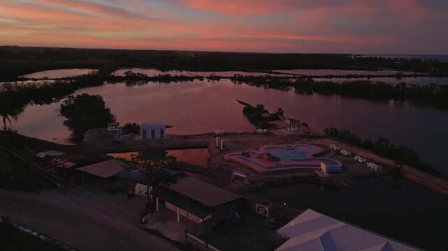 Cinematic aerial of Tondol rice fields and rural road glowing under sunset light, showcasing peaceful countryside scenery in Anda, Pangasinan.