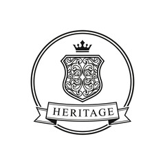 Vintage heraldic emblem with ornate shield, crown, and 'Heritage' banner in a classic circular frame