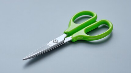 A pair of children's safety scissors with green handles is shown on a transparent background. The scissors are in focus and are well lit, highlighting their design for kids