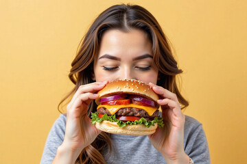 Happy Woman Eating Delicious Burger on Bright Yellow Background