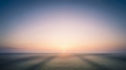 Obraz premium A serene sunrise over a vast ocean with gentle waves and soft light rays emanating from the horizon viewpoint