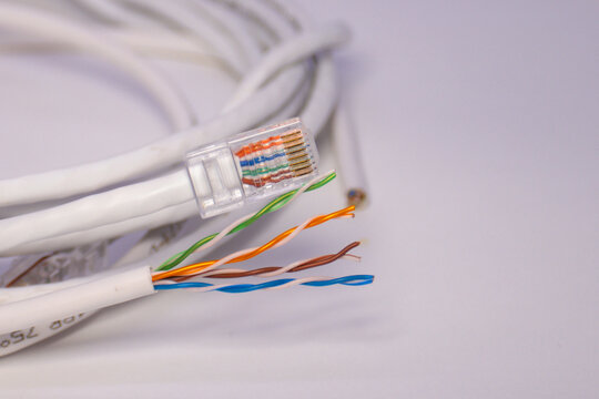 Ethernet cable with exposed colored wires and RJ45 plug, showing network wiring detail and internet connection setup