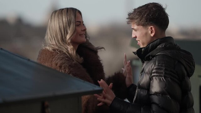 A romantic couple is holding hands in Paris France The young woman and man are in love with a cityscape in the background The scene depicts a relationship affection and connection in Europe.