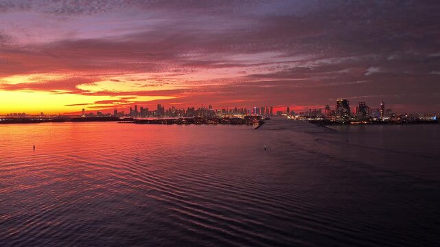 Miami sunset aerial sea. City skyline view. Sunrise cityscape. Sunset dramatic sky Miami city. Seascape with cityscape on sunrise. Night cityscape of Miami with sea and dramatic sky