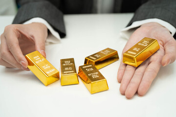 Asian woman holding gold bar in finance business.