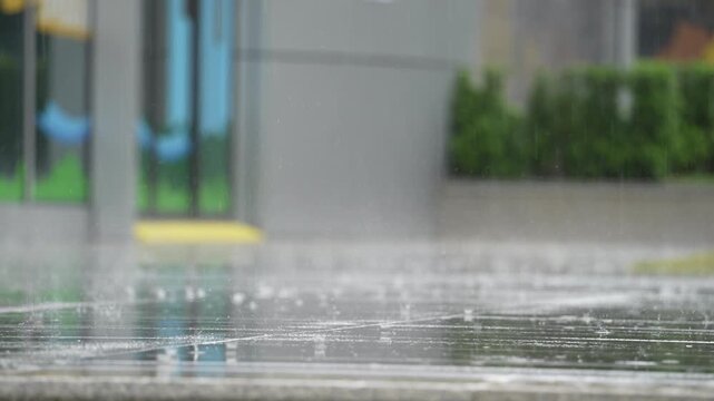 raindrops on concrete floor during downpour. heavy rain in the city.