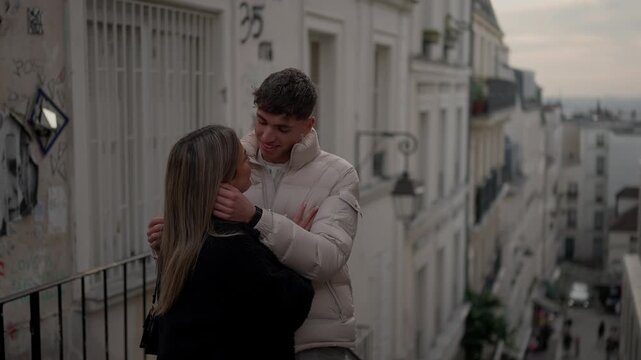 A romantic couple embraces on a street in the Montmartre district of Paris France The man and woman are in love and affectionate enjoying their time in the European city on an overcast.