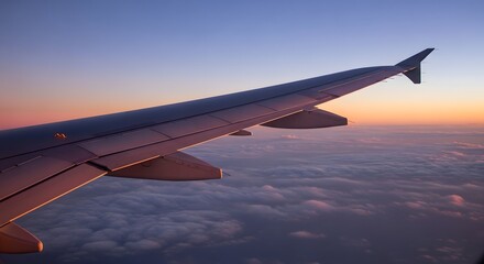Obraz premium Airplane wing soaring through the sky during a breathtaking sunset