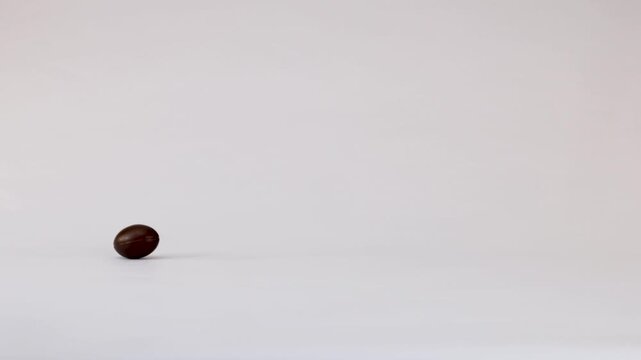 Miniature Chocolate Footballs Falling and Bouncing on a White Background
