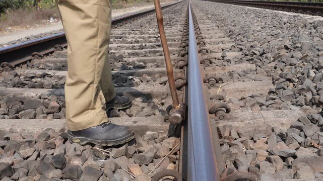 Worker Hammering Elastic Rail Clip onto Railway Track