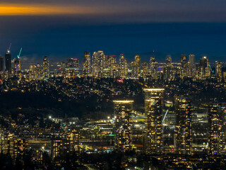 Vibrant Night Skyline Of A Modern City With Tall Buildings And Glowing Lights Over Burnaby