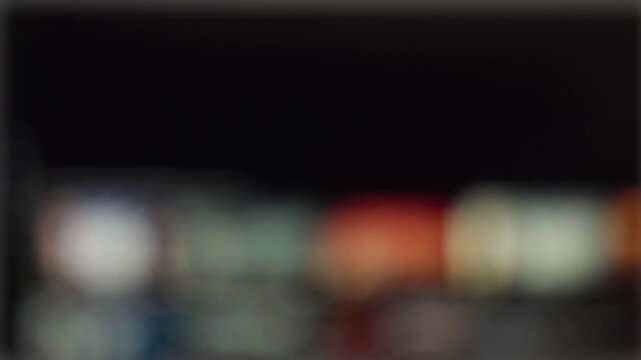 Abstract blurred television screen showing streaming platform interface with colorful movie thumbnails and digital entertainment concept