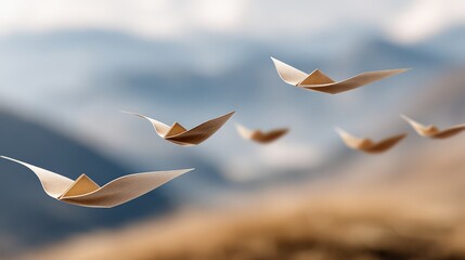 Multiple paper-like objects shaped like birds in flight. They have a tan or light-brown organic color, appearing to be made of thick, textured paper or thin wood veneer.