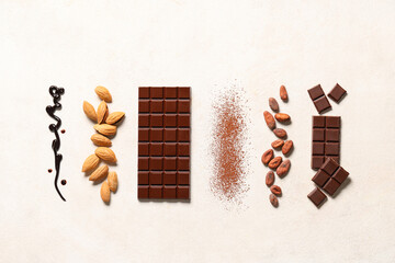 Obraz premium Sweet chocolate with almond nuts, cocoa beans and powder on white background
