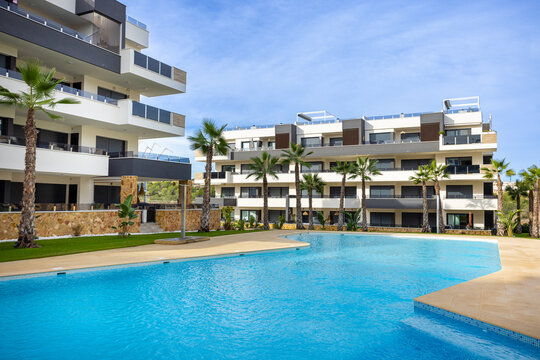 Luxury modern apartment pool courtyard exterior with palm gardens