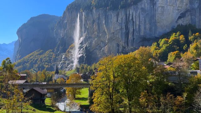Lauterbrunnen Valley Staubbach Falls waterfall The Church post card View Bernese Highlands Switzerland Schweiz Jungfrau region sunny morning blue sky Fall Autumn Swiss Alps canyon cliffs landscape