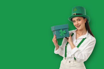 Naklejka premium Young woman in green outfit holds a gift box for celebration