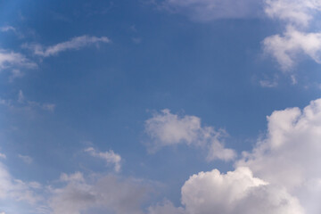 Fototapeta premium Blue sky background with scattered white fluffy clouds