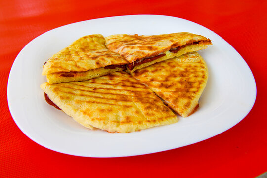 Turkish karisik atom Ayvalik tost. Sucuklu, Kasarli, kavurmali bazlama  karisik tost. Flat baked bread toasted. Karisik bazlama tost . Yarim uc ceyrek ekmek arasi karisik tost. Top view. Turkish toast