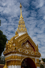 Fototapeta premium Phra That Phanom, iconic Buddhist stupa with golden carvings and white architecture, rising against a bright blue sky. Sacred Thai temple landmark, rich cultural heritage and spiritual atmosphere