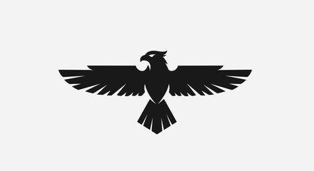 Fototapeta premium Black eagle silhouette with wings spread against white background