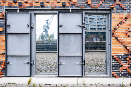 Industrial architecture facade with brick door and window reflection showing urban texture and symmetry in minimal front view for modern design concept