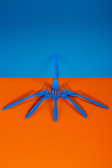 Blue plastic forks on a colored background