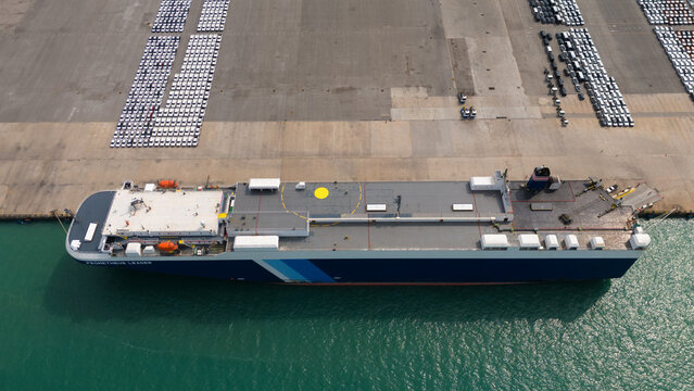 Top view of port, electric car shipping yard and intercontinental shipping industry.