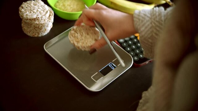Weighing Rice Cakes On Electronic Kitchen Scales. Calculating Calories And Food Portions For Healthy Diet 