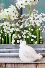Florist at work: woman shows how to make Easter floral table decoration with arabian star flowers and gypsophila paniculata twigs in simple wooden box. Step by step, tutorial.