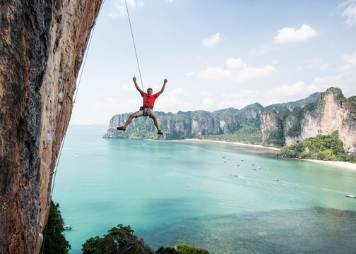 Thailand, Krabi, Thaiwand wall, climber abseiling from rock wall above the sea